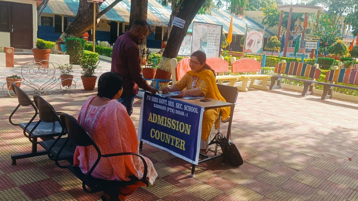 The school's admission counter set up in the courtyard, with a teacher helping parents