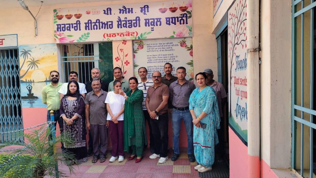 Staff at the school entrance below the PM SHRI signboard